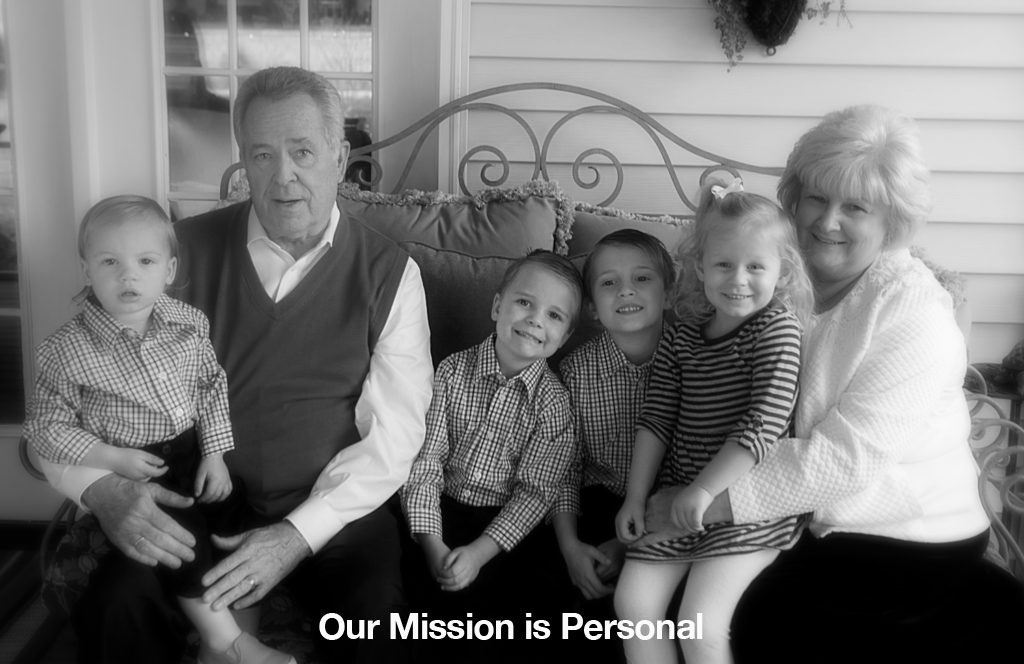 A heartwarming image of grandparents sitting with their grandchildren, engaged in joyful conversation. This image emphasizes the importance of good hearing for family bonds. We offer a free hearing test.