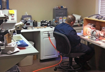 An image of Ernie, our hearing aid technition, doing repairs